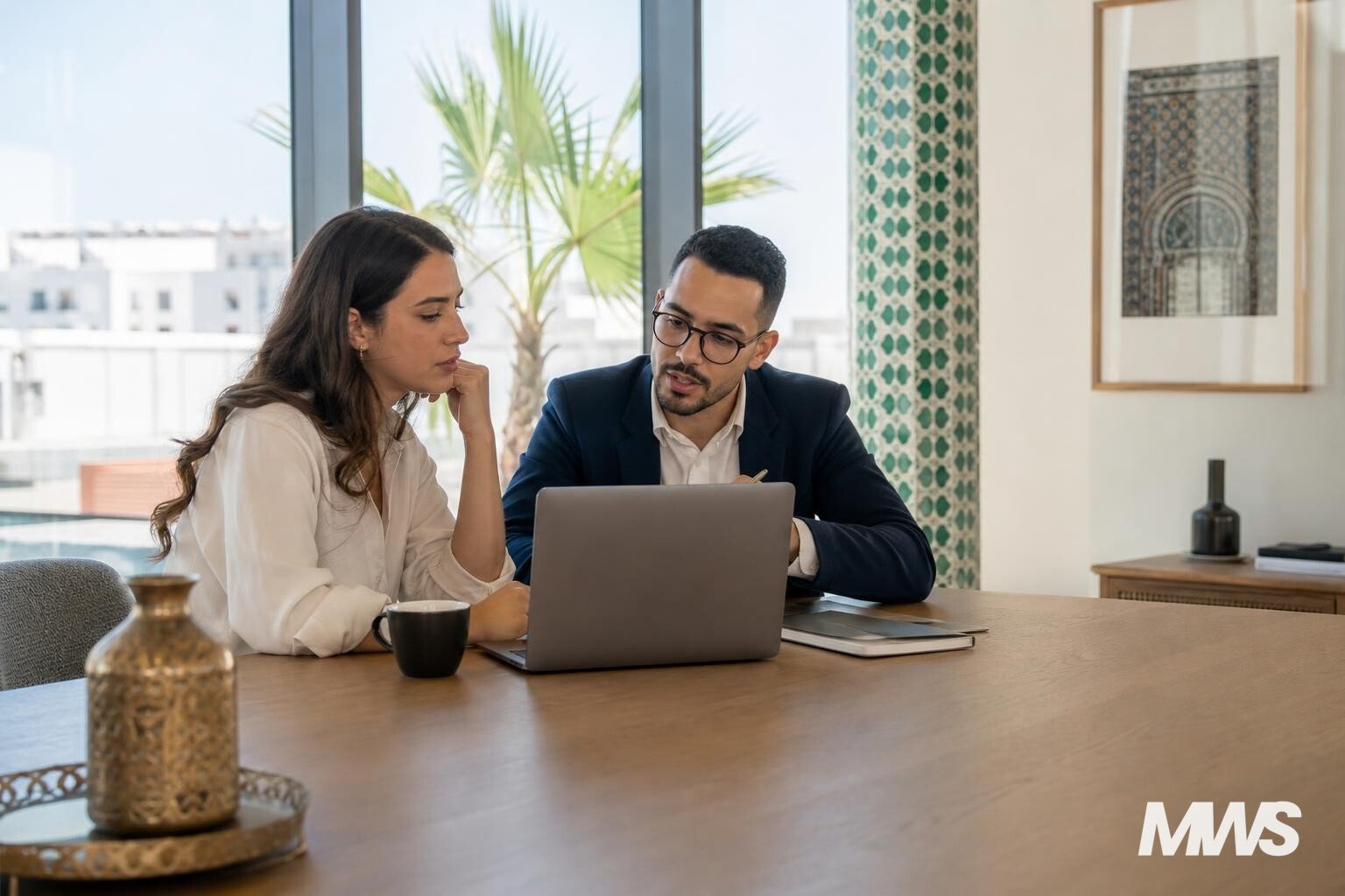 Consultant SEA analysant une campagne Google Ads avec un client dans un bureau à Rabat