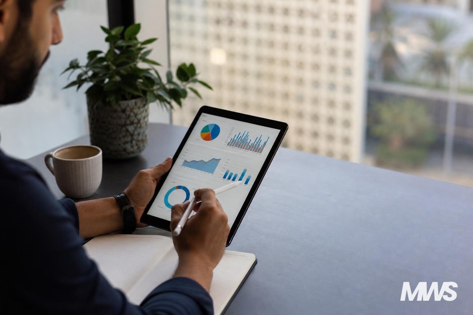 Un expert SEA analysant des données de campagne sur une tablette dans un bureau moderne